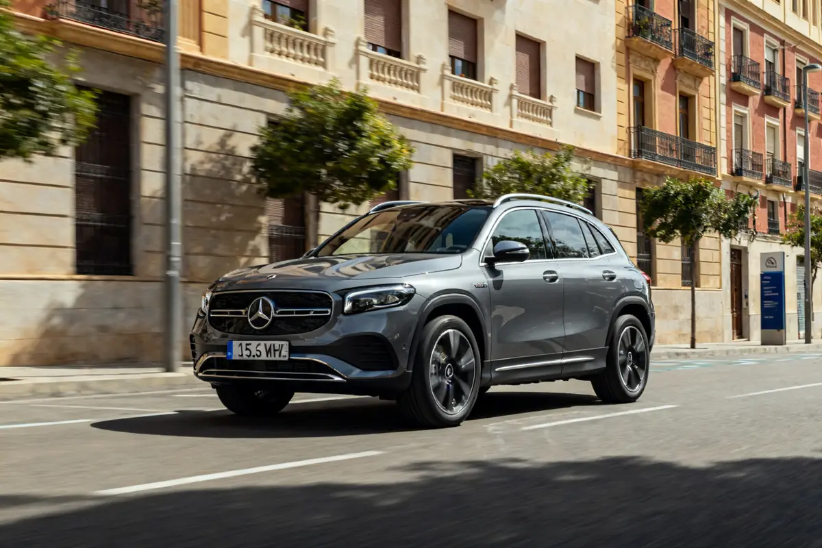 Coche Mercedes GLA 2026 gris circulando por una calle urbana con edificios clásicos alrededor